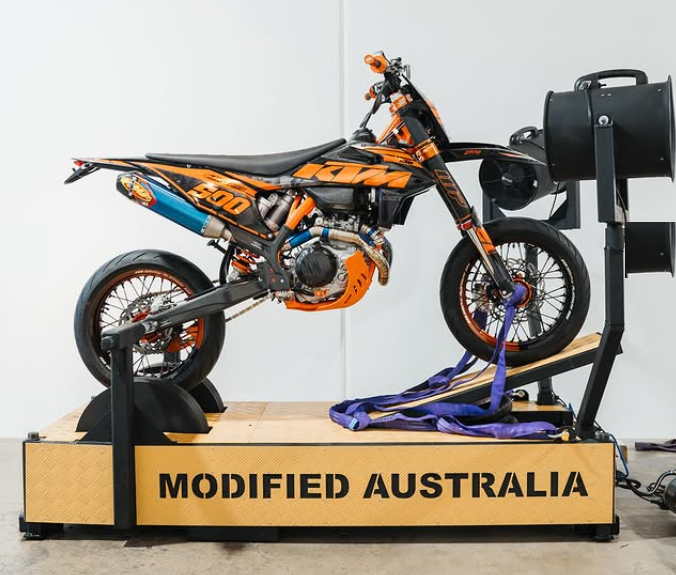 KTM supermoto strapped onto a Wild Wheelies wheelie machine, ready for training